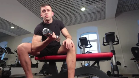 Bodybuilder working out with bumbbells weights at the gym Stock Footage 73168658