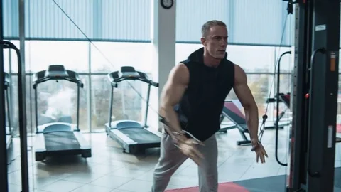 Bodybuilder workout in gym machine. Loop Stock Footage 82332216