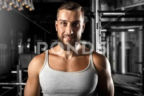 Bodybuilding. Bearded man standing at gym smiling happy to camera close-up Stock Photos