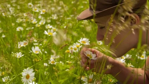 Bohemian woman smelling flowers on the meadow Stock Footage