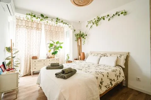 Boho bedroom decorating with plants creating cozy atmosphere Stock Photos