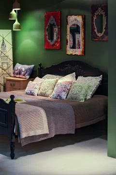 Boho bedroom rustic design interior. Ethnic paintings and pillows with patter Stock Photos