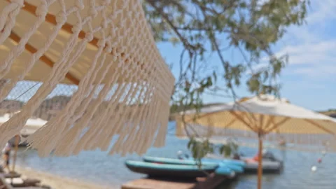 Boho Chic Beach Umbrella at Luxury Coastal Resort 4K Cinematic Vidéo 336691932