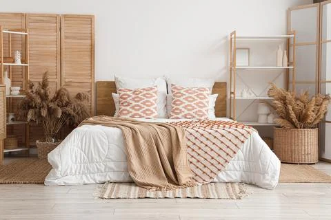 Boho chic bedroom interior with a comfortable bed, decorative pillows, and Dr Stock Photos