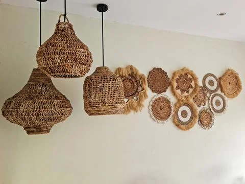 Boho Chic Interior Decor: Woven Rattan Lamps and Wall Baskets Hanging on a .. Stock-Fotos