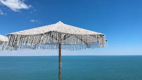 A Boho-Chic Vibe: White Knitted Umbrella with Tassels Stockbeeldmateriaal 339097575