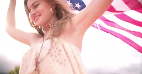 Boho girl flying an American flag down a country road Stock Footage