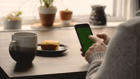 Boho Man In Wool Sweater Sipping Coffee And Scrolling through Social Media Stock Footage 117692597