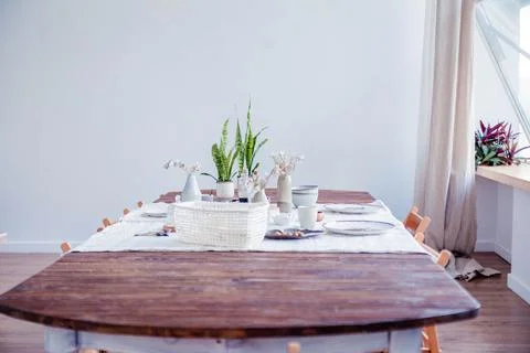 Boho style dining table set with natural elements, featuring potted plants Stock Photos