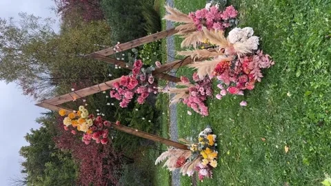 Boho wedding arch in park. The arch is decorated with flower arrangements of Stock Footage 264134179