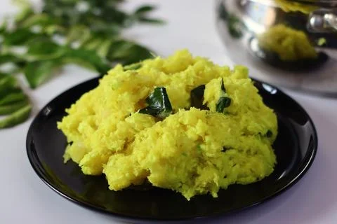 Boiled and mashed tapioca, blended with turmeric and garnished with curry lea Stock Photos