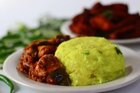 Boiled and mashed tapioca served with spicy chicken curry and crispy fried fi Stock Photos