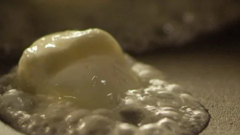 Boiled butter fall on frying pan RAPID 50fps Stock Footage 74652640