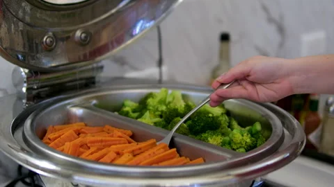 Boiled carrots and broccoli in the buffet chops boiled carrot into perfect cubes Stock Footage 317879458