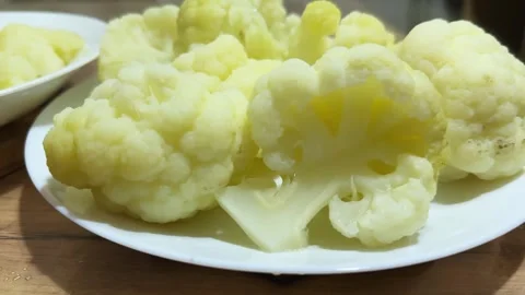 Boiled cauliflower pieces on two plates, front view close-up Stock Footage 324967749