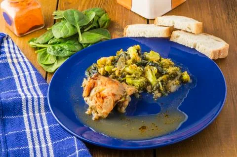 Boiled chicken with broccoli and spinach on blue plate Stock Photos