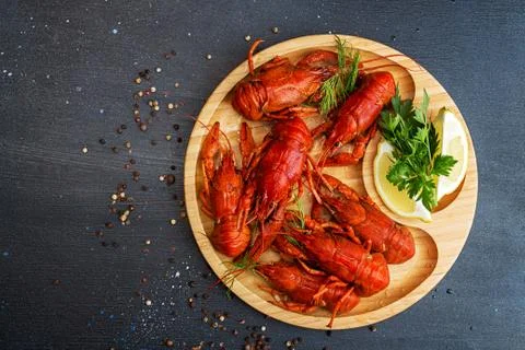Boiled cooked crayfish crawfish ready to eat on wooden plate on black backgro Stock Photos