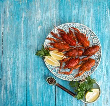 Boiled cooked crayfish crawfish ready to eat on blue plate over on blue woode Stock Photos