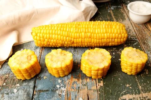 Boiled corn and chopped corn ear on rustic wooden table Stock Photos