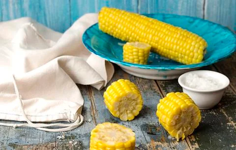 Boiled corn on deep blue plate Stock Photos
