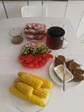 Boiled corn tomatoes and cucumbers with toast from gray bread Stock Photos