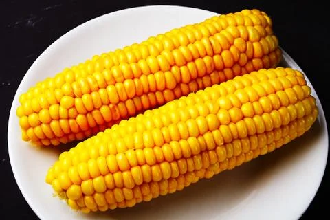 Boiled corn on a white plate Foto stock