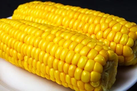 Boiled corn on a white plate, selective focus, close-up Foto stock