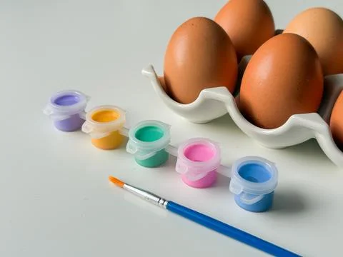Boiled Easter eggs with paints before decorating on white background close .. Stock Photos