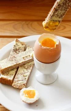 Boiled egg and buttered toast Stock Photos