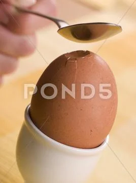 Boiled Egg being cracked open with a spoon Stock Photos