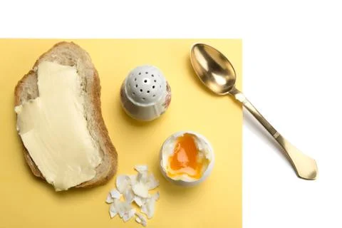 Boiled egg, bread with butter, salt cellar and brass spoon Foto stock