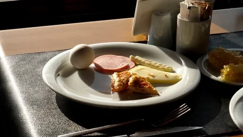 Boiled egg, cooked sausage slices, some cheese and little pastry on plate 動画素材 83807871