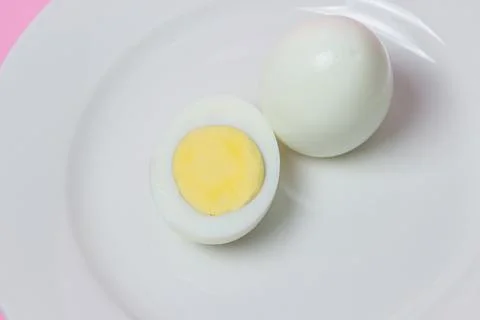 A boiled egg cut in half on a plate. Healthy breakfast. Stock Photos