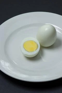 A boiled egg cut in half on a plate. Healthy breakfast. Stock Photos