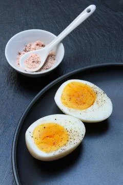 Boiled egg halved and shell with natural salt Stock Photos