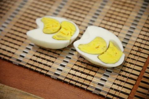The boiled egg is irregular in shape. Two yolks inside. Cut in half. Organic Stock Photos