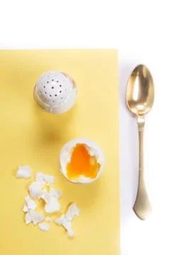 Boiled egg, salt cellar and brass spoon Stock Photos