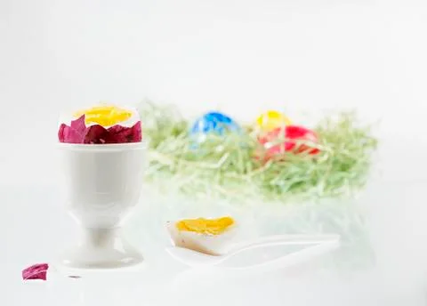 A boiled egg with the top cut off, in an eggcup, with an Easter nest of Stock Photos
