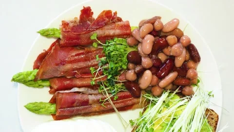 Boiled eggs with asparagus, beans, ham and toast with avocado Video stock 134735727