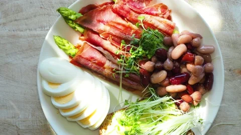 Boiled eggs with asparagus, beans, ham and toast with avocado Stock Footage 134736470