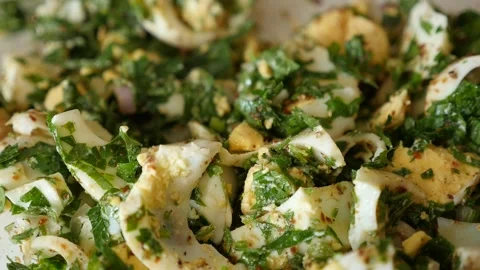 Boiled eggs with lots of greens, one person stirs the plate, 動画素材 248903734