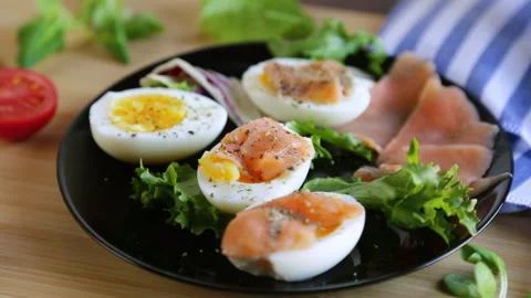 Boiled eggs with salted red fish, herbs and seasonings in a plate . Stock Footage 251591481