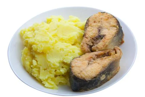Boiled mashed potatoes on a plate with fried salmon on white background Stock Photos