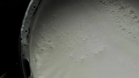 Boiled milk pot on black background top down view macro Stock Footage 335968640