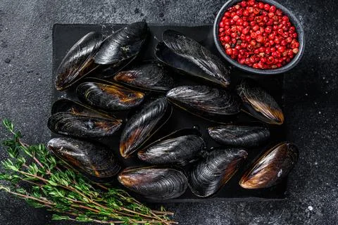 Boiled Mussels in shells on a marble board. Black background. Top view Stock Photos