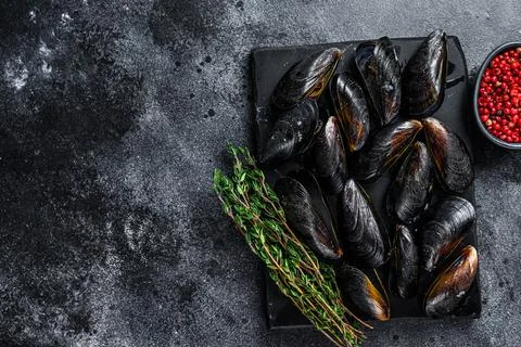 Boiled Mussels in shells on a marble board. Black background. Top view. Copy Stock Photos