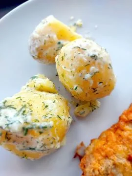 Boiled Potatoes Mixed With Dill Served on a Plate With a Side of Baked Dish.. Stock Photos