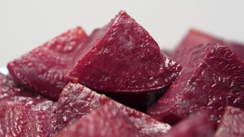 Boiled red beetroot cut into pieces rotates on grey background, close-up shot Stock Footage 310737794
