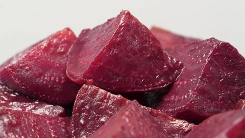 Boiled red beetroot cut into pieces rotates on grey background, close-up shot Stock Footage 315217691