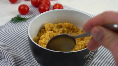 Boiled red lentils in a deep dish. Mixing boiled cereals. Stock Footage 139511715